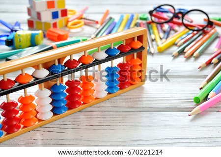 Close up view of abacus scores mental arithmetic with colorful back to school supplies over white table. Space for text. Flat lay style Royalty-Free Stock Photo #670221214