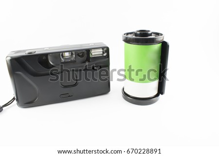 Old photo camera with a green roll on a white background.
