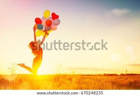 Beauty girl running and jumping on summer field with colorful air balloons over Sunset clear sky. Silhouette, Happy young healthy woman enjoying nature outdoors. Running and Spinning female. Flying