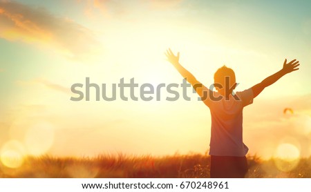 Little boy raising hands over sunset sky, enjoying life and nature. Happy Kid on summer field looking on sun. Silhouette of male child in sunlight rays. Fresh air, environment concept. Dream of flying Royalty-Free Stock Photo #670248961