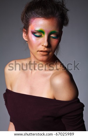 The beautiful girl with a creative make-up on face