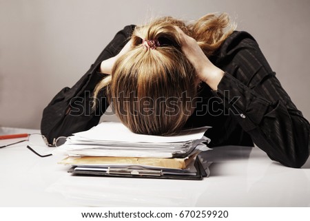 Young business woman tired from office work with documents. (Body language, gestures, psychology concept)