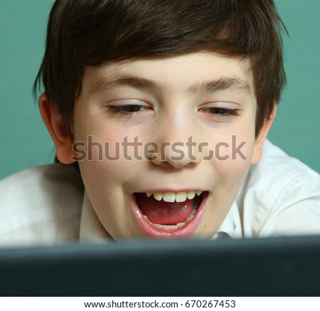 teen boy laughing watch comedy movie on laptop close up photo