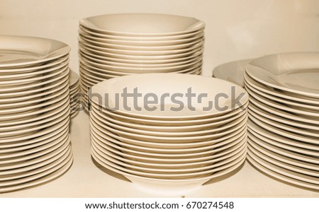 Piles of white plates in warm tones