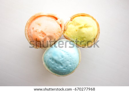 Ice cream in a cup of waffle light. view from above. Close-up shooting. Orange, yellow, blue. gentle colors.