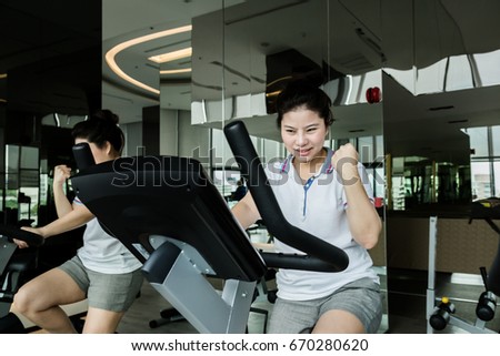 sport and health concept with asian beautiful girl exercise with equipment in fitness room