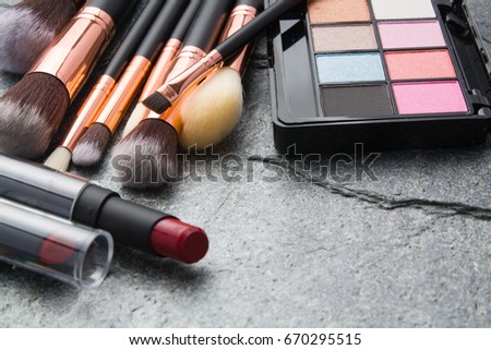 various makeup products on dark background with copyspace