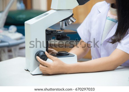 Medical technique with microscope in working laboratory.