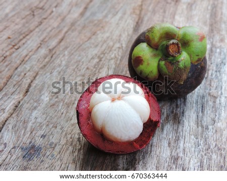Mangosteen and cross section showing the thick purple skin and white flesh of the queen of friuts, Delicious mangosteen fruit arranged on a hemp sack background, Mangosteen flesh.
