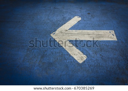 The old white arrow symbol on the blue bike lane used to indicate driving directions