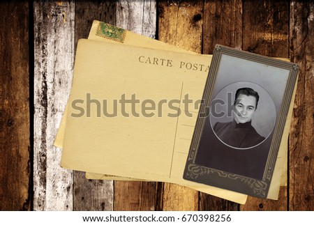 Vintage post cards and retro photo on old wooden planks. Inscription on the card - carte postale - postcard in french