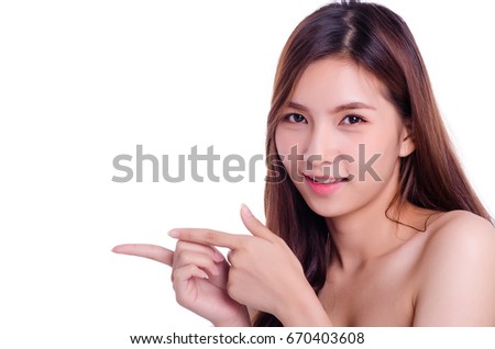 asian young beautiful woman surprise showing product .Beautiful girl with curly hair pointing to the side . Presenting your product. Isolated on white background. Expressive facial expressions