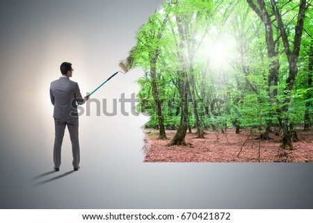 Businessman painting nature picture with roller brush