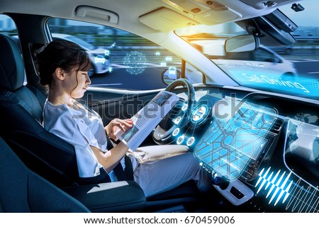young woman reading a magazine in a autonomous car. driverless car. self-driving vehicle. heads up display. automotive technology. Royalty-Free Stock Photo #670459006