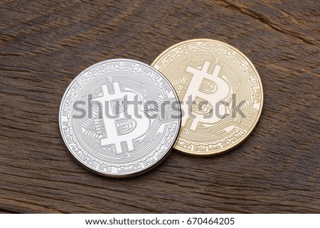 Silver and golden bitcoins on wooden background. High resolution photo.