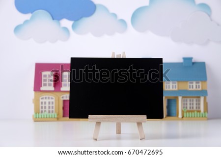 mini blackboard and model house as background