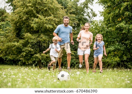 Family playing soccer in summer with their children Royalty-Free Stock Photo #670486390