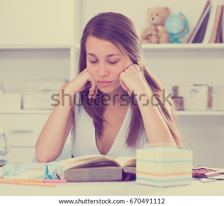 School girl is reading text at home.