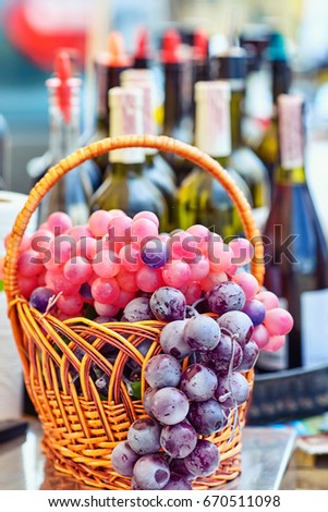 Still life with wine bottles, glasses and basket.