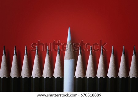 White pencils stand out from the many crowds alike. Black fellows on white boards, leadership, independence, initiative, strategy, disagreement, thinking different, business success ideas.