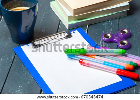 Workplace with coffee cup, spinner and book