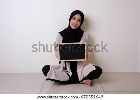 portrait of proud Muslim holding blank sign blackboard