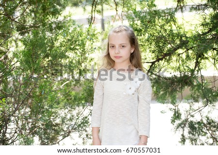 Portrait of a lovely little happy princess girl with long blonde curly hair at summer sunny day