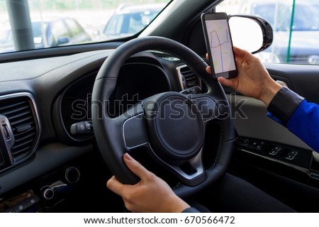 Cropped image of woman using phone during test drive while sitting in car