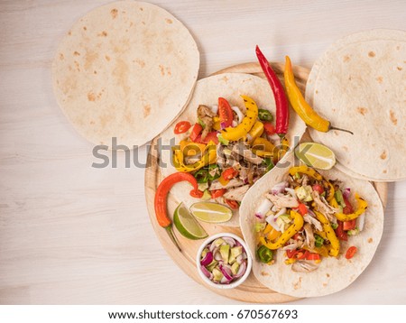 Cooking tacos and fajitas on pita with vegetables salad, meat, pepper and corn on rustic wooden white table background. Recipe traditional food. Top flat view, overhead.