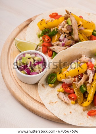 Tacos and fajitas on pita on rustic wooden white table background. Homemade recipe book. Top view, overhead.