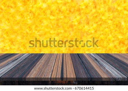 Empty wooden table or plank with yellow color like a surface of sun or fire on background for product display.