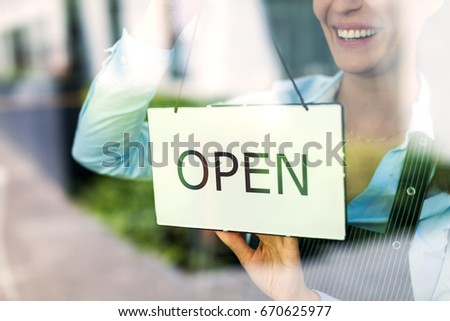 Woman holding open sign in cafe
