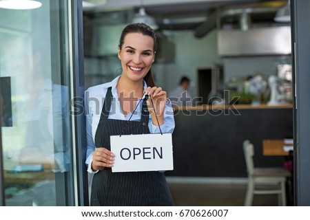 Woman holding open sign in cafe
