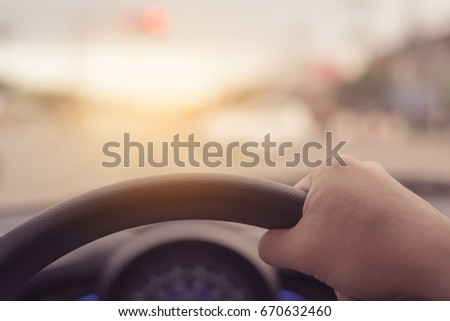 vintage tone image of people driving car on day time for background usage.(take photo from inside focus on driver hand)