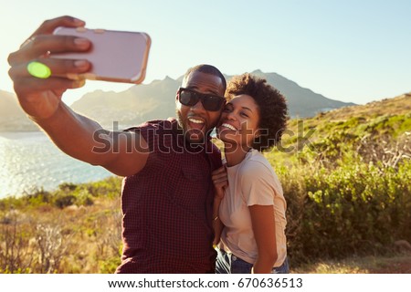 Young Couple Pose For Holiday Selfie On Clifftop Royalty-Free Stock Photo #670636513
