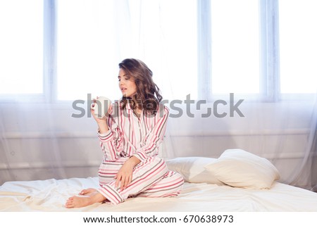 girl in pajamas woke up in the morning and drink coffee or tea