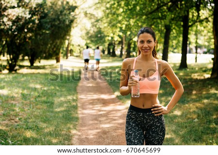 Portrait of a happy young woman smiling with water bottle