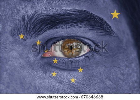 Human face and eye painted with US state flag of Alaska