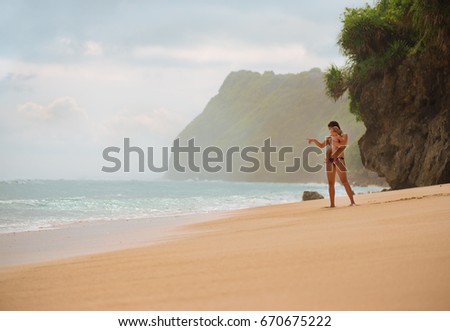 Portrait of young mother with her adorable little boy on the ocean beach. Happy woman hugging a baby and enjoying vacation by the sea. On the empty beach. Motherhood, family and lifestyle.