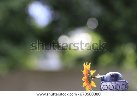 the green  tank toy and yellow flower and white and green bokeh on green background
