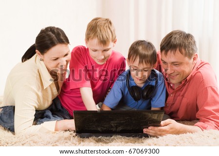 portrait of a nice family of four with a laptop