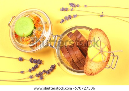 Bread crumbs lie in a glass jar on a yellow background