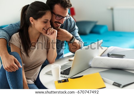 Woman buying online stocks actions.She using laptop while her husband sitting beside and support her. Royalty-Free Stock Photo #670747492