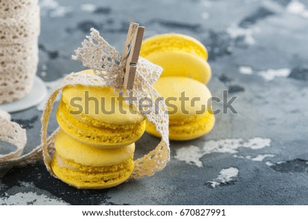 Yellow macaroons and lace on dark concrete background