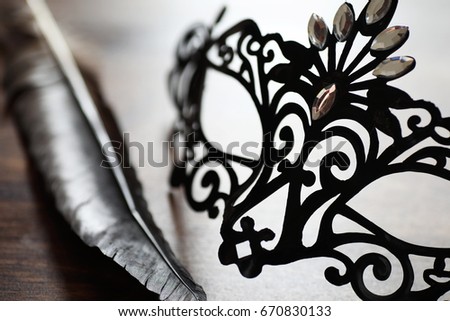 Black mask on the wooden background with space for text