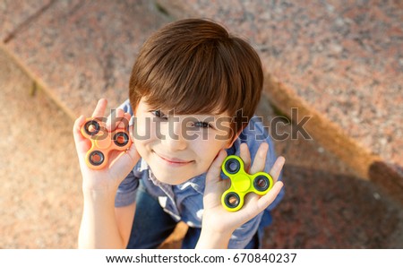 happy boy playing with fidget spinner