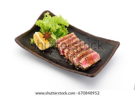 Tataki (tuna fillet) on a black plate isolated on white background, Royalty-Free Stock Photo #670848952