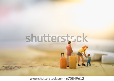 Family and travel concept. Father, mother and son miniature figures with luggage standing, playing and take care child on world map with airplane model as background.
