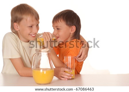 two brothers drink juice on a white