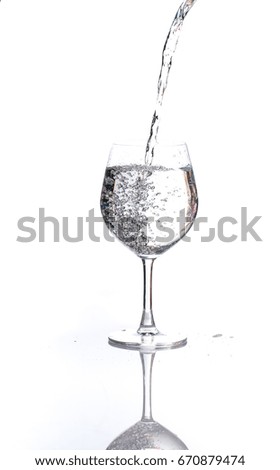 pouring water into a glass wine on white background